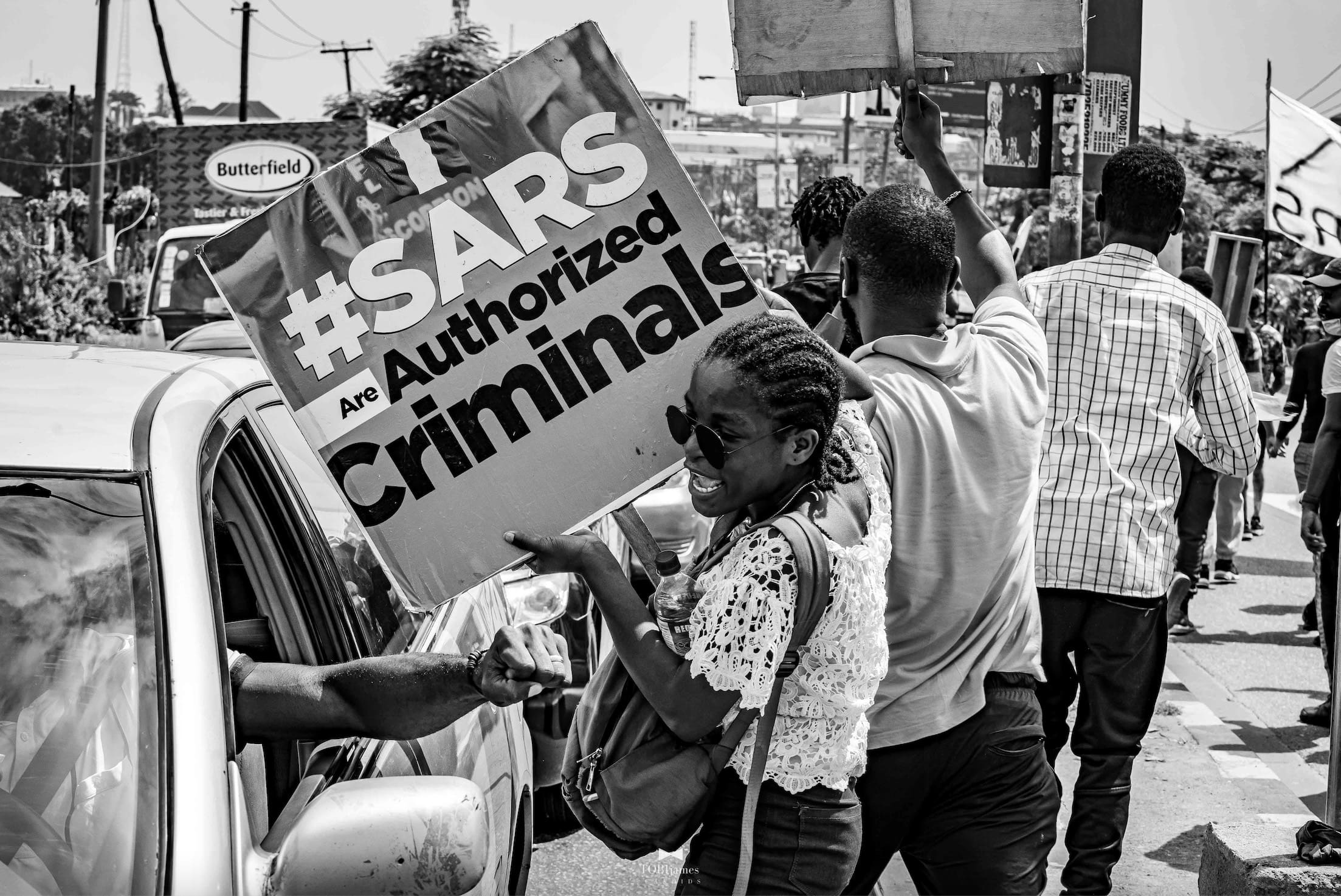 A protester in Nigeria holds a sign against police brutality.