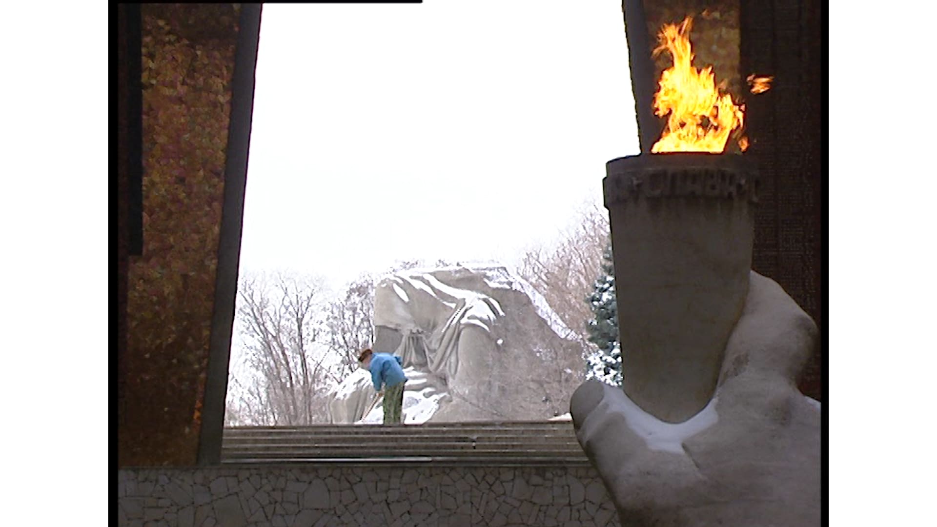 A frame from Trauma Zone showing a pedestrian and a statue with torch.