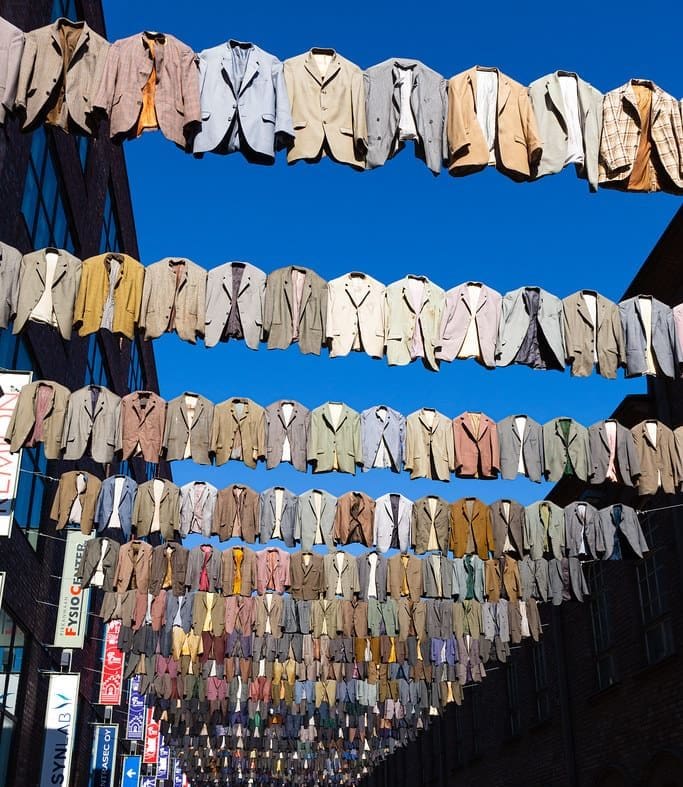 An image showing dozens of business suits strung up on a clothes line outdoors. Credit: "Laundry day..." by Janne Räkköläinen is licensed under CC BY-SA 2.0.