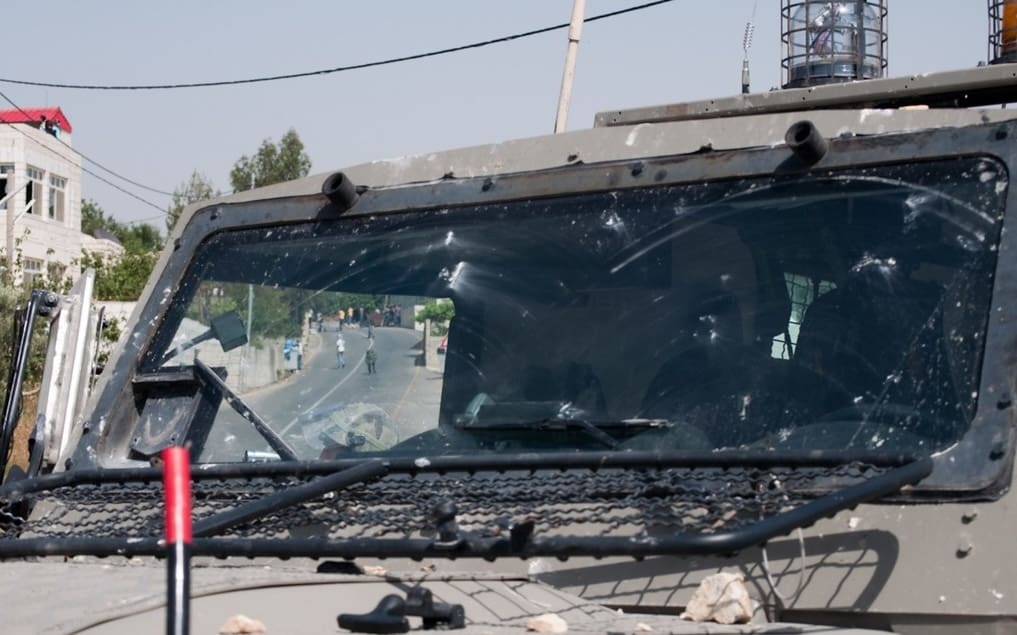An image of an Israeli military jeep that has been pelted with stones. Credit: "A Demonstration in the village 'A NABI SALIH' Occupied Palestinian Territory May 7th 2010 - 20" by http://edo.medicks.net is licensed under CC BY-NC-SA 2.0.