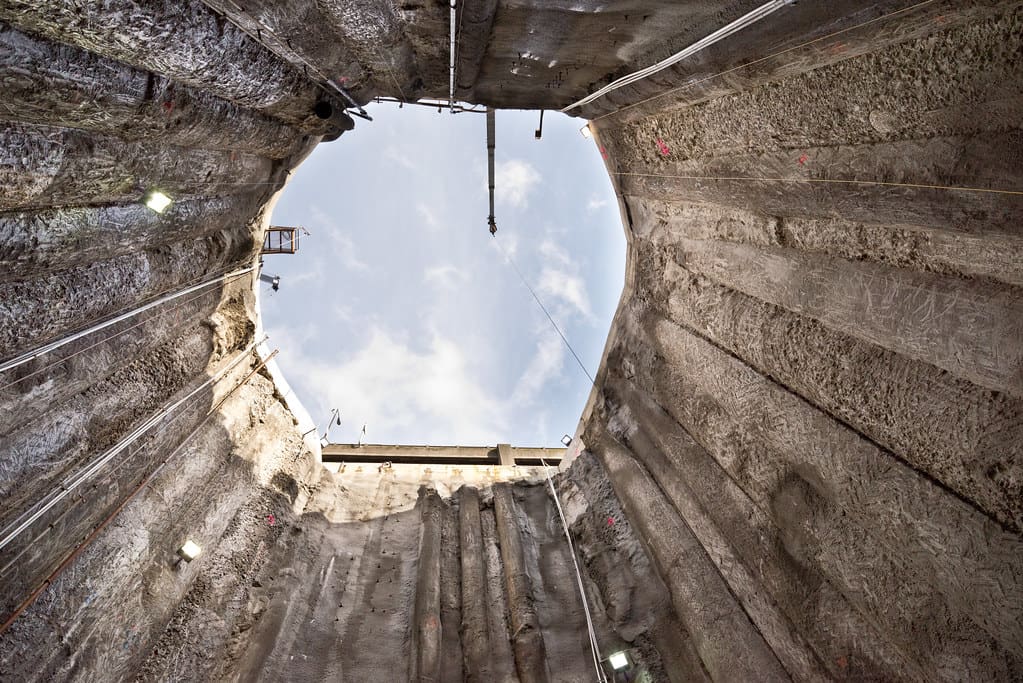 An image of an industrial pit, looking up from the bottom. "Looking up from the bottom of Bertha’s access pit" by WSDOT is licensed under CC BY-NC-ND 2.0.