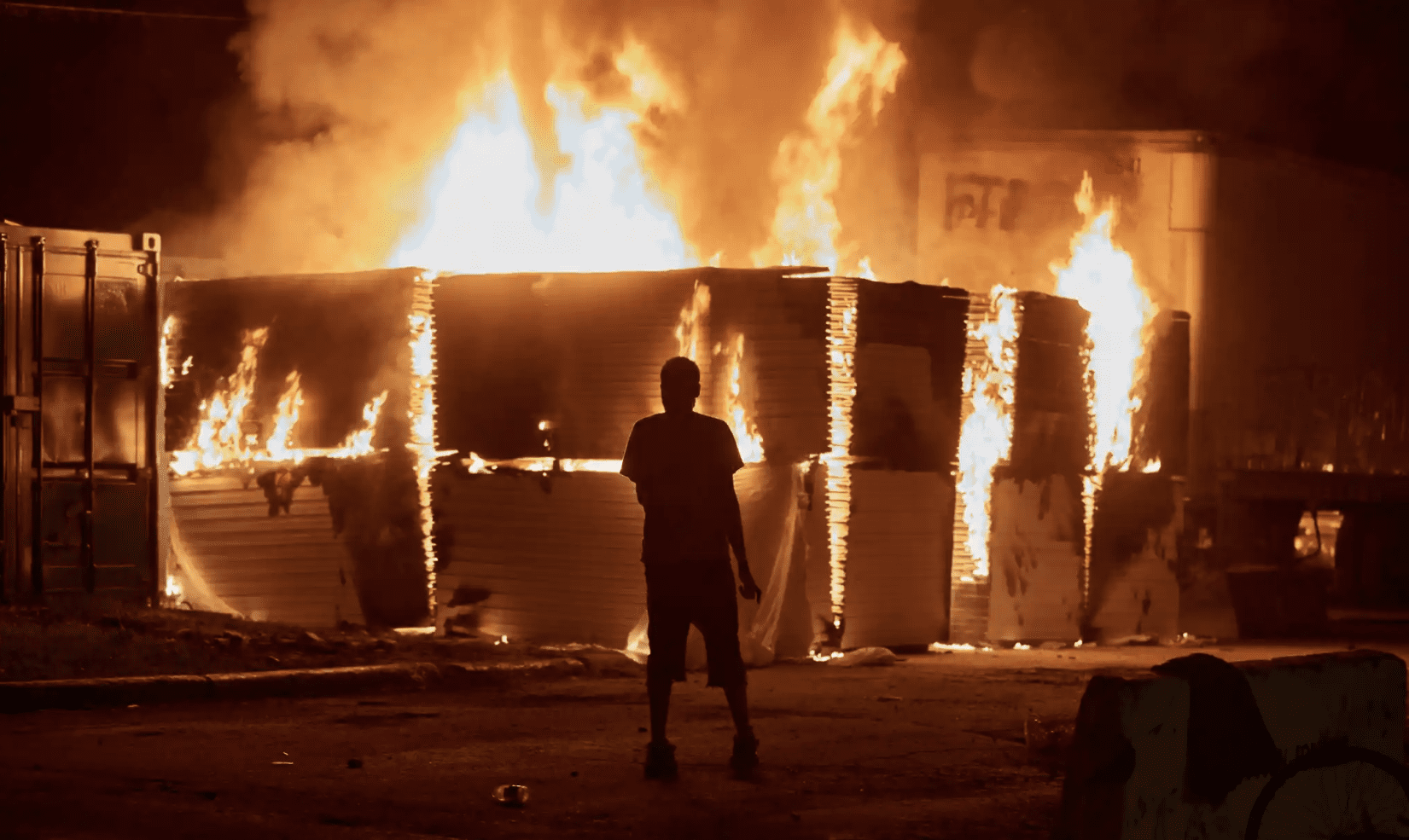 An image of a burning building next to Minneapolis's 3rd precinct, which was torched by actionists during the 2020 George Floyd Rebellion. Picture taken May 27, 2020. REUTERS/Adam Bettcher